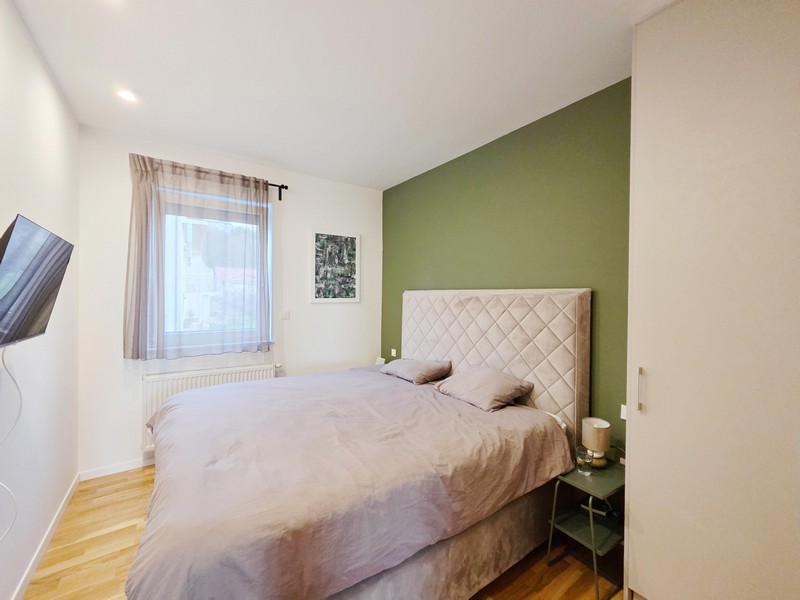 Schlafzimmer mit Doppelbett und grüner Akzentwand