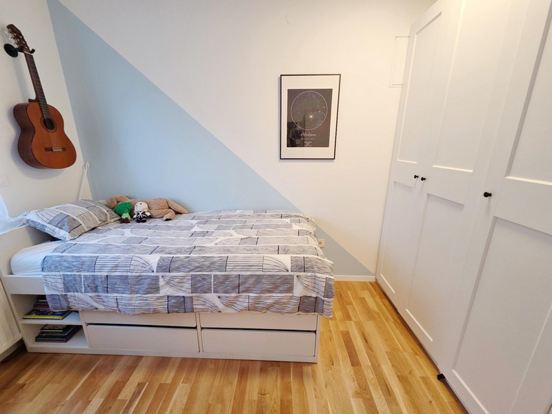Kinderzimmer mit Bett, Gitarre und Kleiderschrank