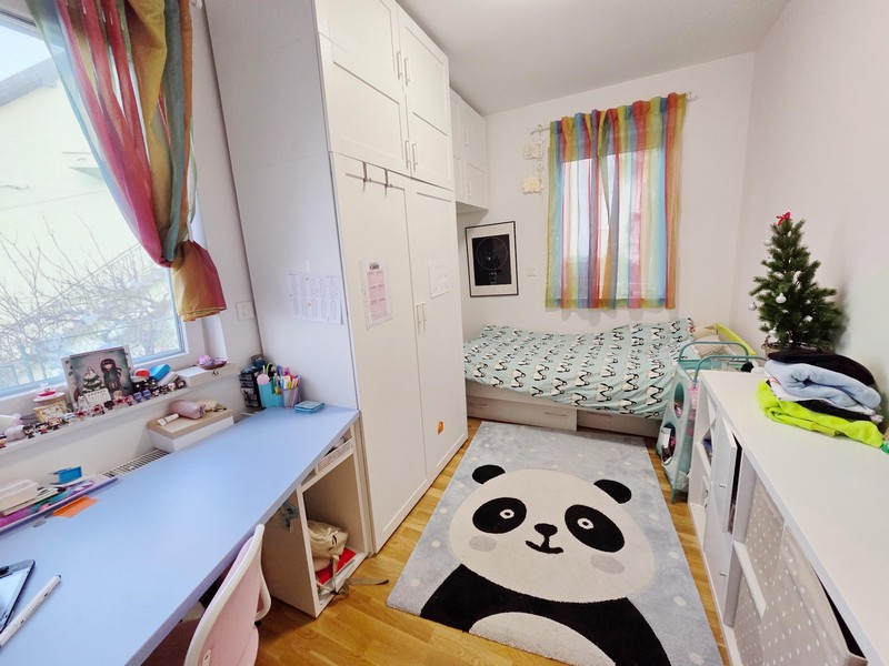 Kinderzimmer mit Pandateppich, Schreibtisch und Schrank