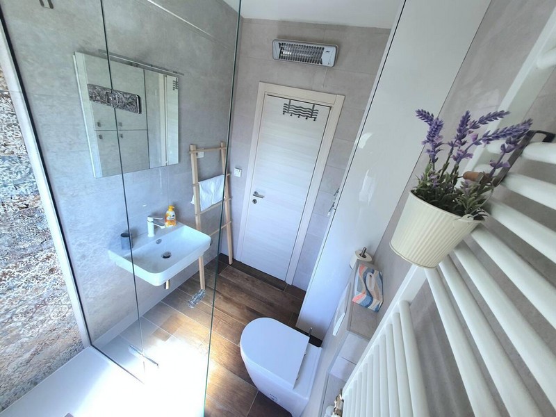 Badezimmer mit Glasdusche und Handtuchheizkörper