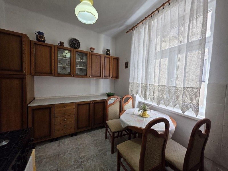 Küche mit Holzschränken und kleinem Sitzbereich