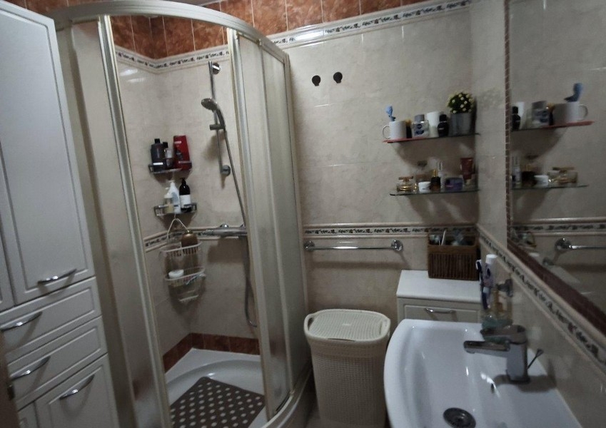 Badezimmer mit Dusche, Waschbecken und Spiegel