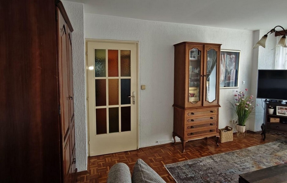 Wohnzimmer mit Parkettboden und klassischen Holzmöbeln