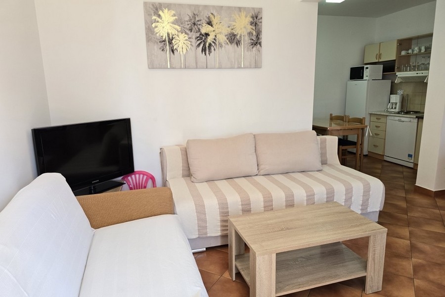 Wohnzimmer mit Sofa, Couchtisch und TV