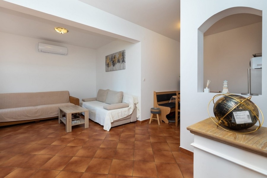 Wohnbereich der Wohnung mit Sitzmöbeln und Durchgang zur Küche