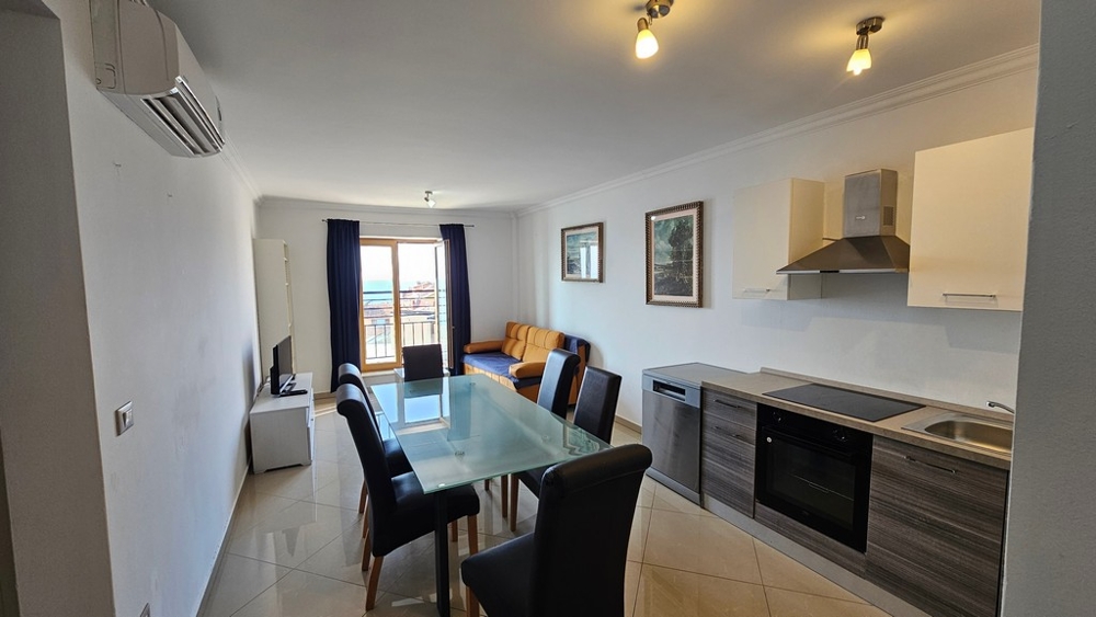 Helles Wohnzimmer mit offener Küche, Essbereich und Blick auf das Meer