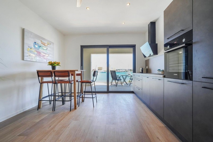 Moderne Küche mit Meerblick und Zugang zur Terrasse
