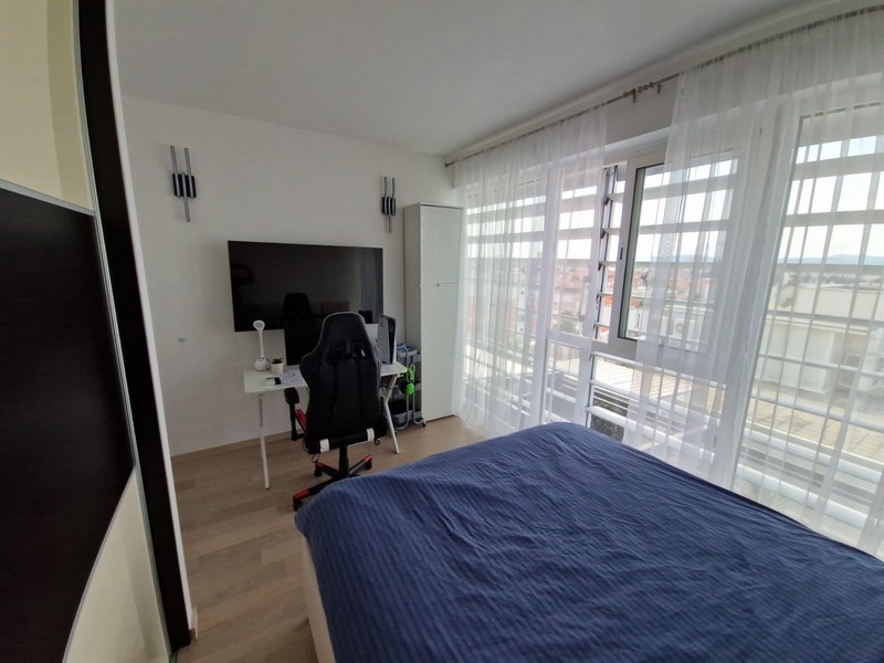 Schlafzimmer mit Arbeitsplatz und Balkonzugang