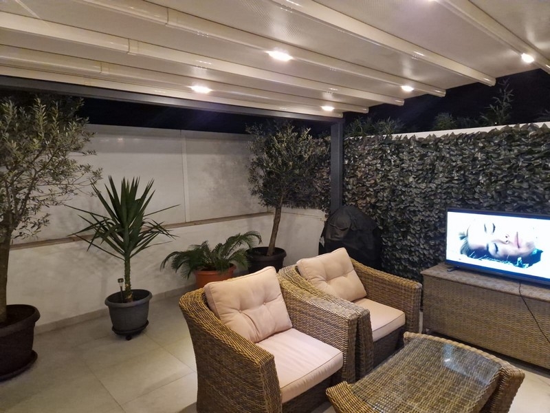 Überdachte Terrasse mit Lounge und Beleuchtung