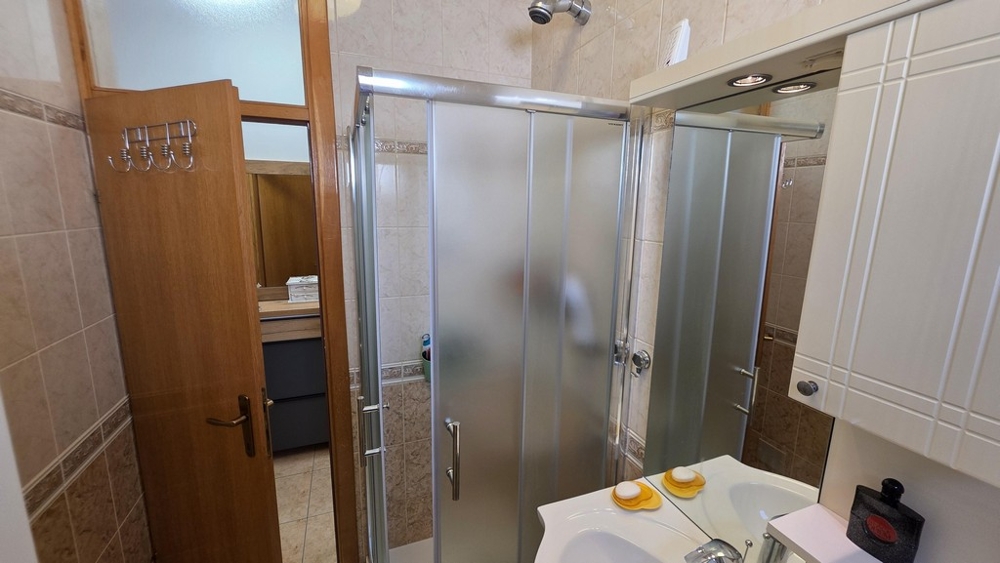 Badezimmer mit Duschkabine und Waschbecken