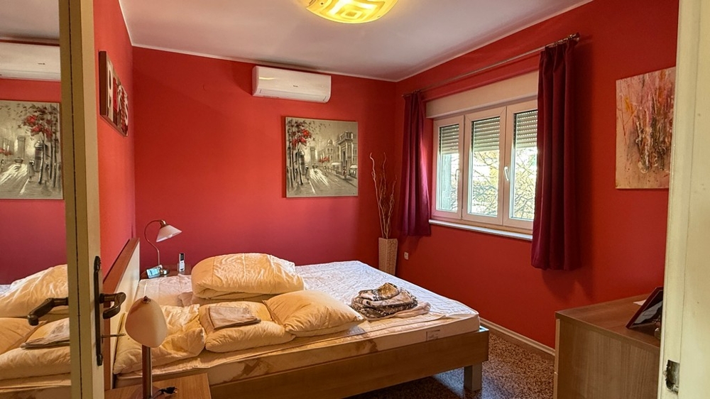 Schlafzimmer mit Fenster und roter Wandgestaltung