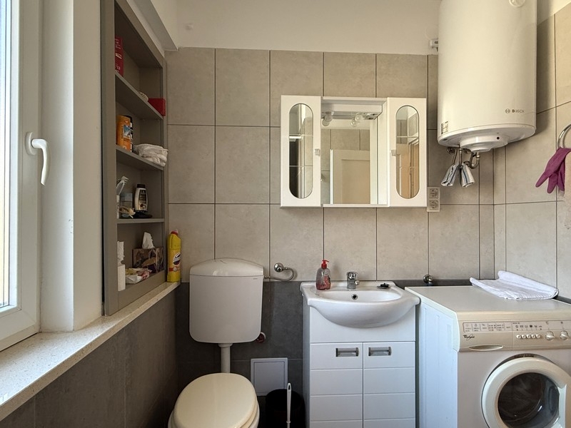 Badezimmer mit Waschmaschine und Waschbecken