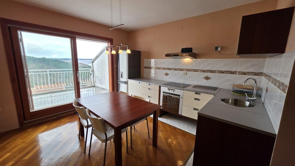 Wohnbereich mit integrierter Küchenzeile und Blick auf die Terrasse. 