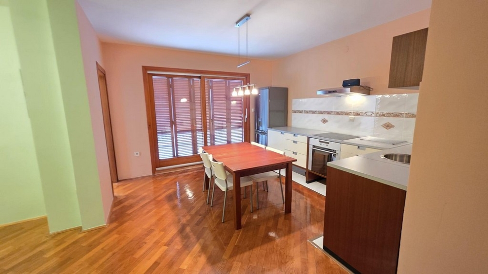 Wohnbereich mit Küche und Esstisch und Zugang zum Balkon