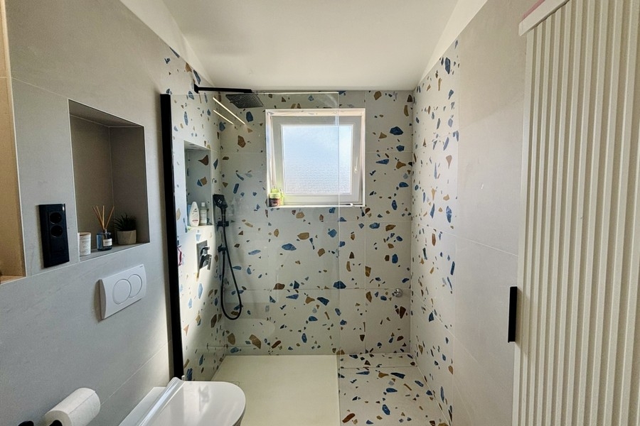 Modernes Badezimmer mit bodengleicher Dusche und Fenster
