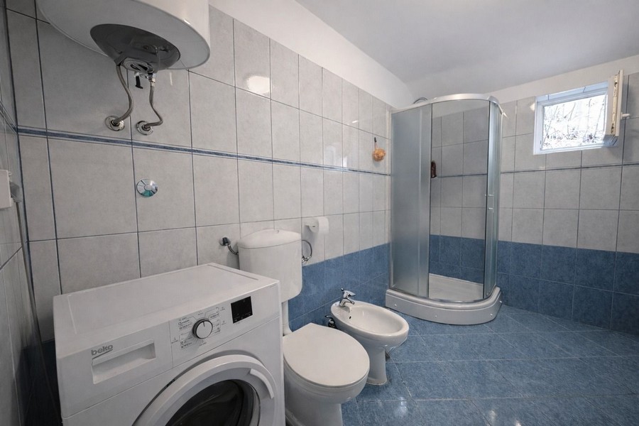 Badezimmer mit Dusche und Waschmaschine