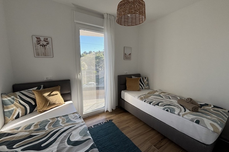 Schlafzimmer mit zwei Einzelbetten und Balkonzugang