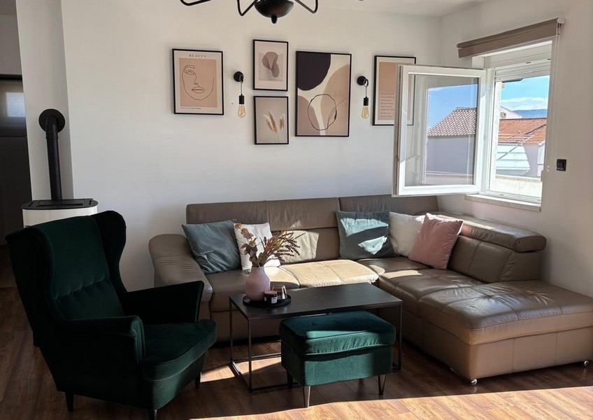 Wohnzimmer mit Balkonzugang und Blick auf Meer und Küstenlandschaft