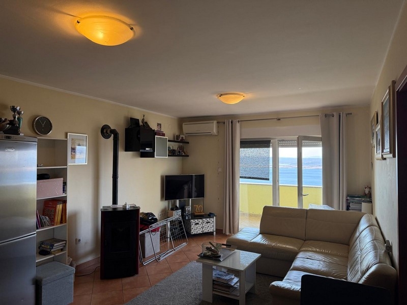 Wohnzimmer mit TV-Bereich und Balkonzugang