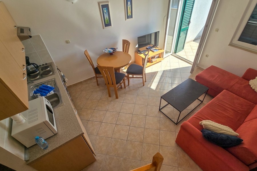 Heller Wohnbereich mit offener Küche und Zugang zum Balkon