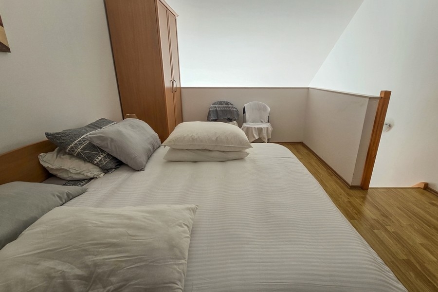 Schlafbereich auf der Galerie mit Doppelbett und Kleiderschrank