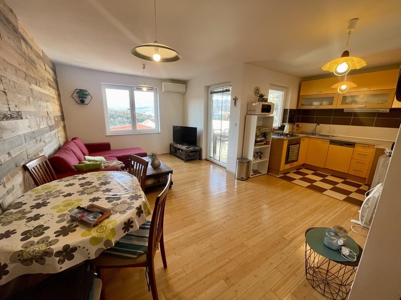 Wohnbereich mit offener Küche und Zugang zum Balkon mit Meerblick