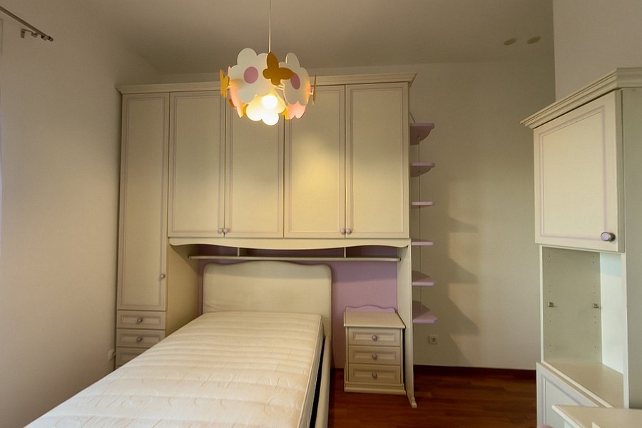 Schlafzimmer mit Einzelbett und maßgefertigten Einbauschränken