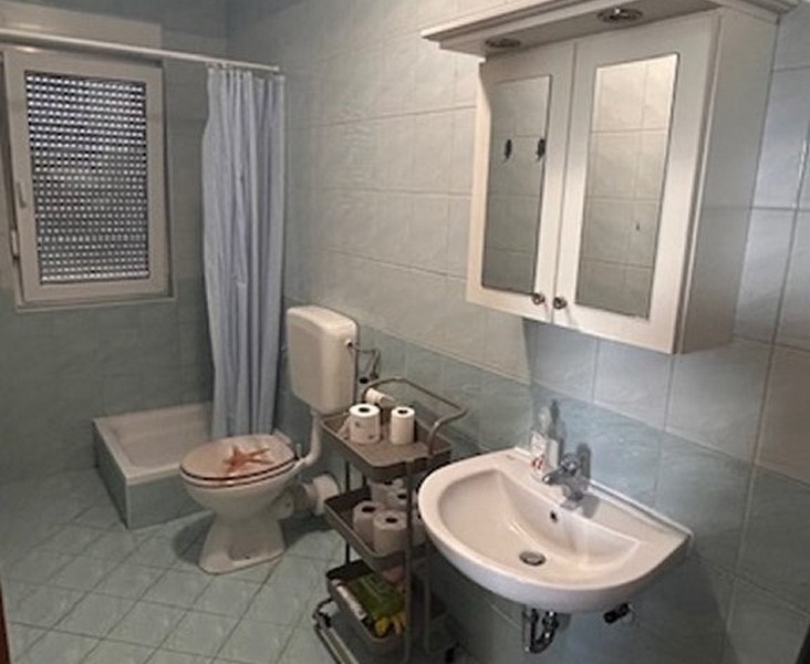 Badezimmer mit Dusche, Waschbecken und Fenster