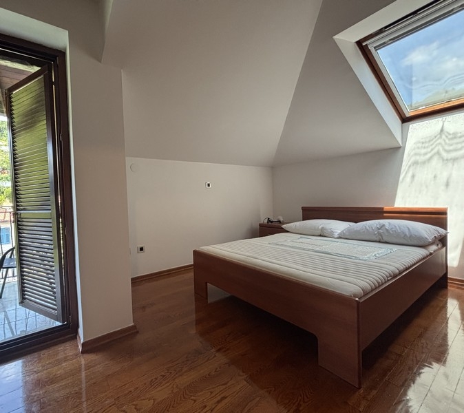 Schlafzimmer mit Zugang zum Balkon und Dachfenster