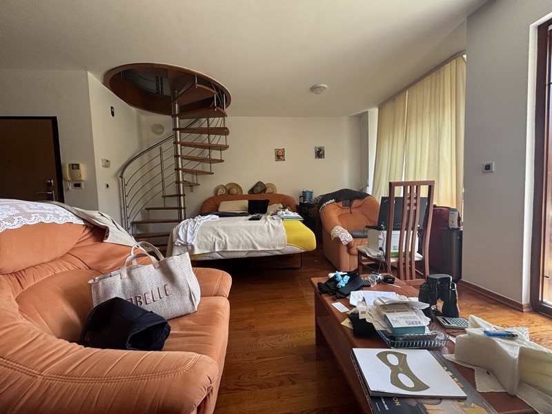 Wohnbereich mit Sofas und Wendeltreppe zur oberen Etage