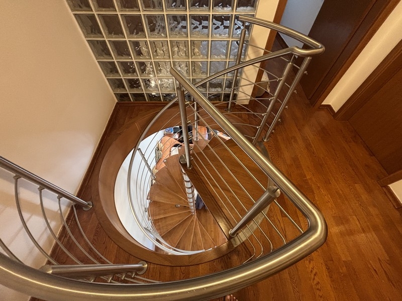 Moderne Wendeltreppe mit Holzstufen und Edelstahlgeländer
