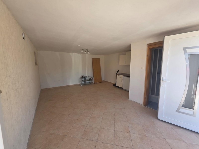 Außenbereich mit gepflasterter Terrasse und Stellplätzen