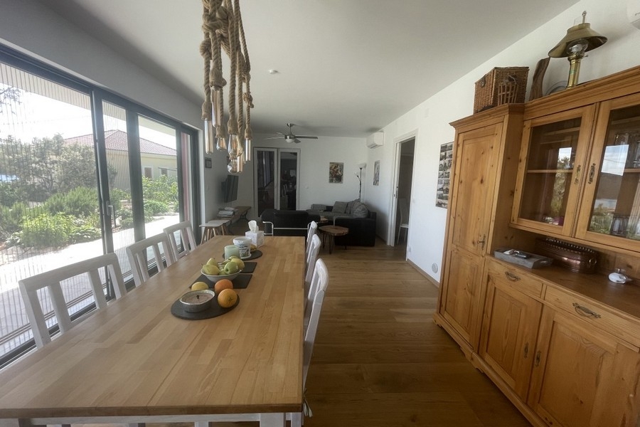 Offener Wohn- und Essbereich mit großen Fensterflächen und Blick ins Grüne