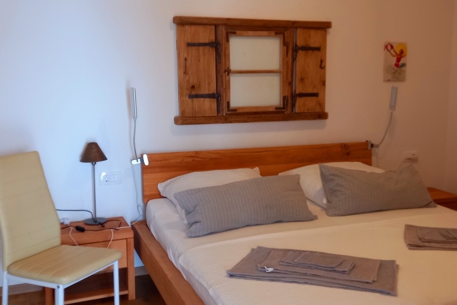 Schlafzimmer mit Doppelbett und schlichter Möblierung