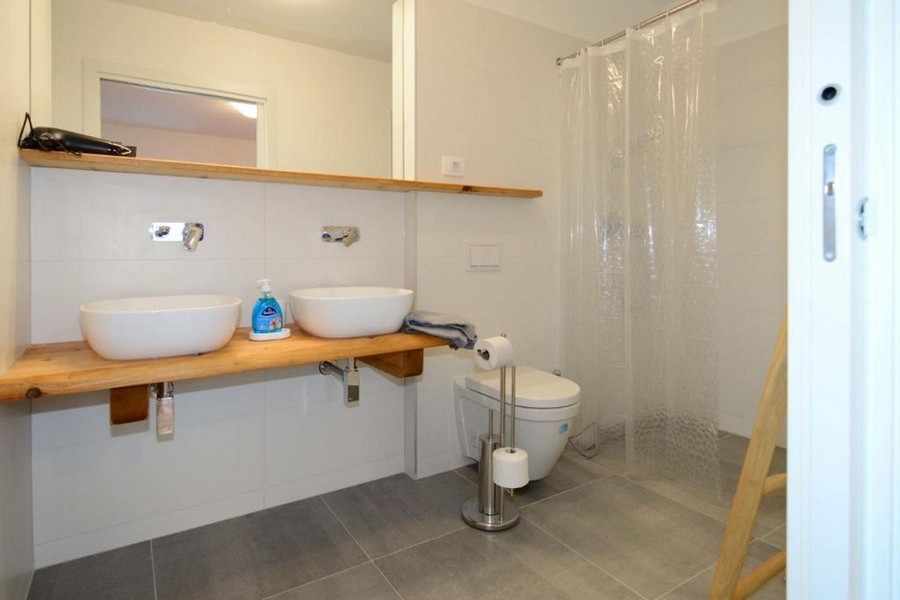 Modernes Badezimmer mit Doppelwaschbecken, Dusche und WC