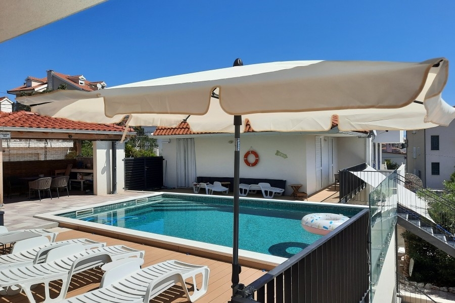 Poolbereich mit Sonnenterrasse und Liegen