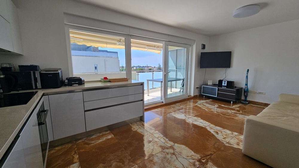 Wohnbereich mit Küche und Zugang zum Balkon mit Meerblick