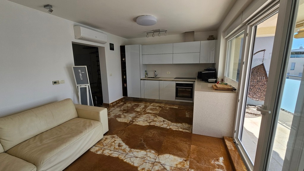 Offener Wohnraum mit moderner Einbauküche und Terrassenzugang