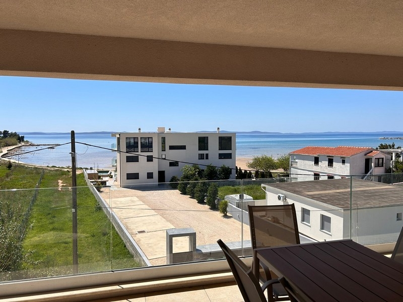Blick von der überdachten Terrasse auf den Strand.
