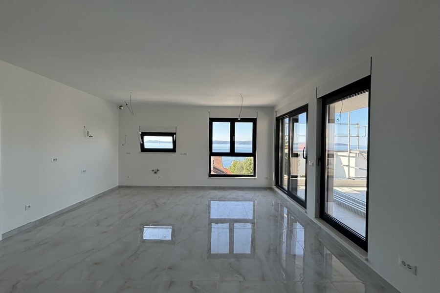 Wohnbereich mit großen Fensterfronten und Meerblick