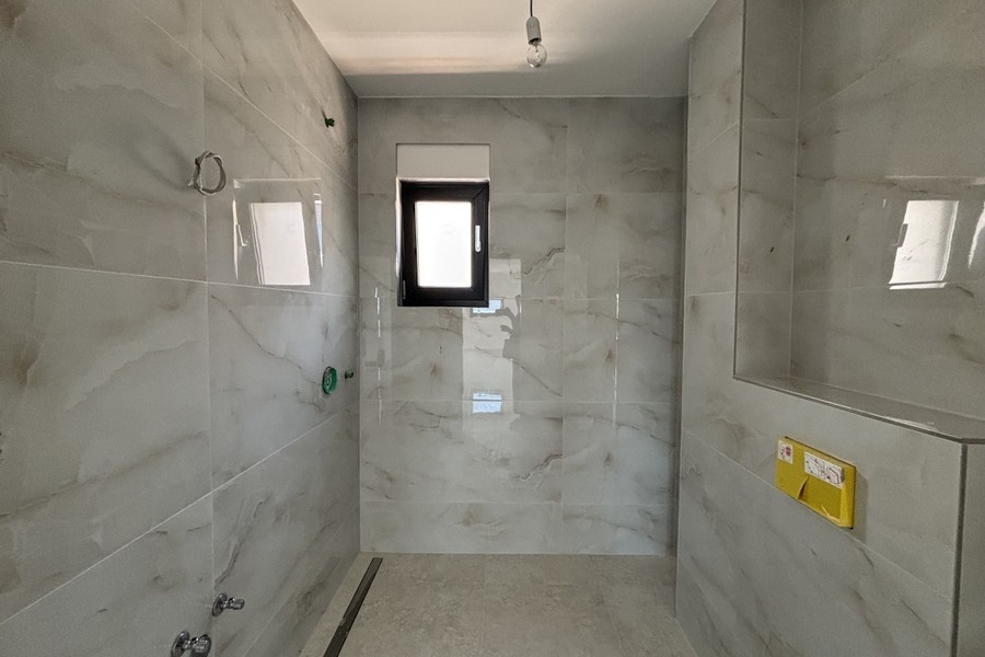 Modernes Badezimmer mit bodengleicher Dusche und Fenster
