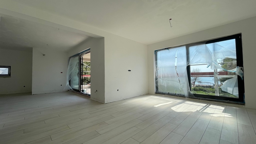 Heller Wohnbereich mit großen Fensterflächen und Zugang zur Terrasse