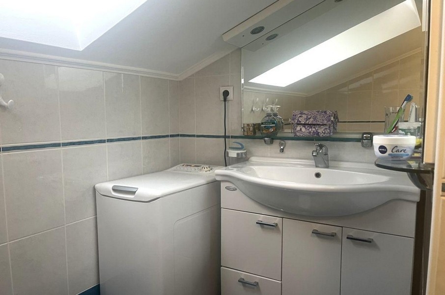 Badezimmer mit Waschmaschine und Waschbecken