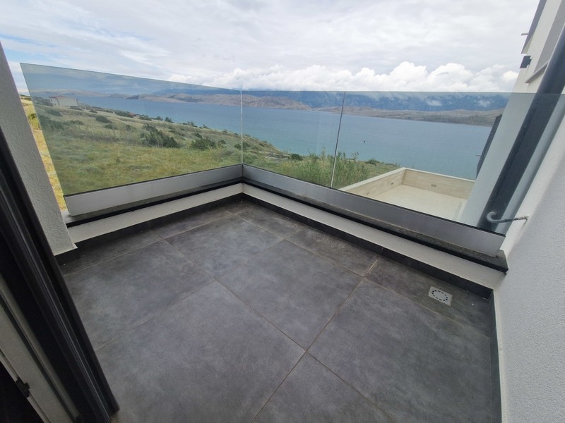 Überdachte Terrasse mit Glasgeländer und Blick auf das Meer
