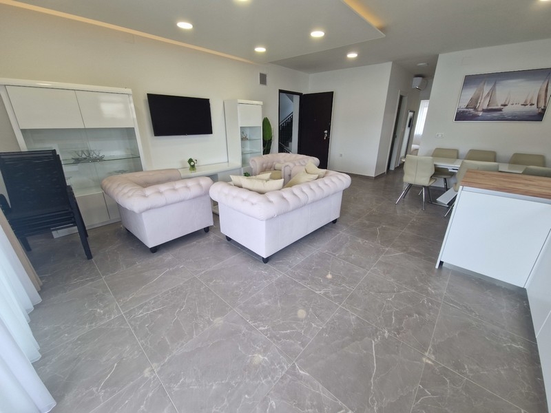 Offener Wohnbereich mit Küche und Meerblick in moderner Wohnung