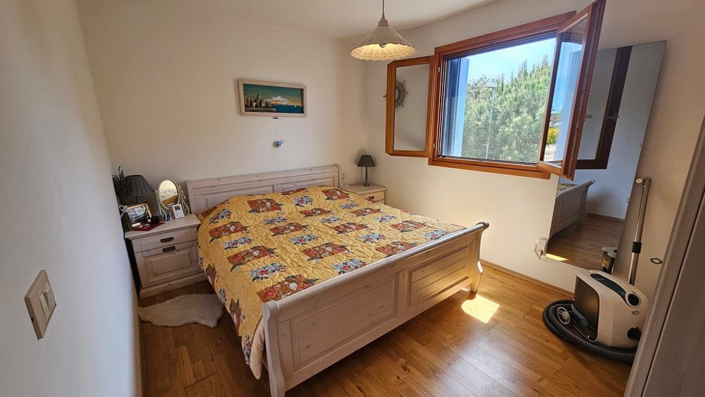 Schlafzimmer mit Holzparkett und Fenster