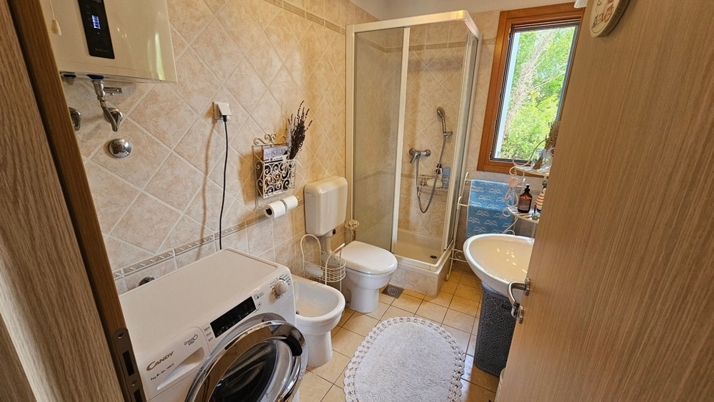 Badezimmer mit Dusche und Waschmaschine