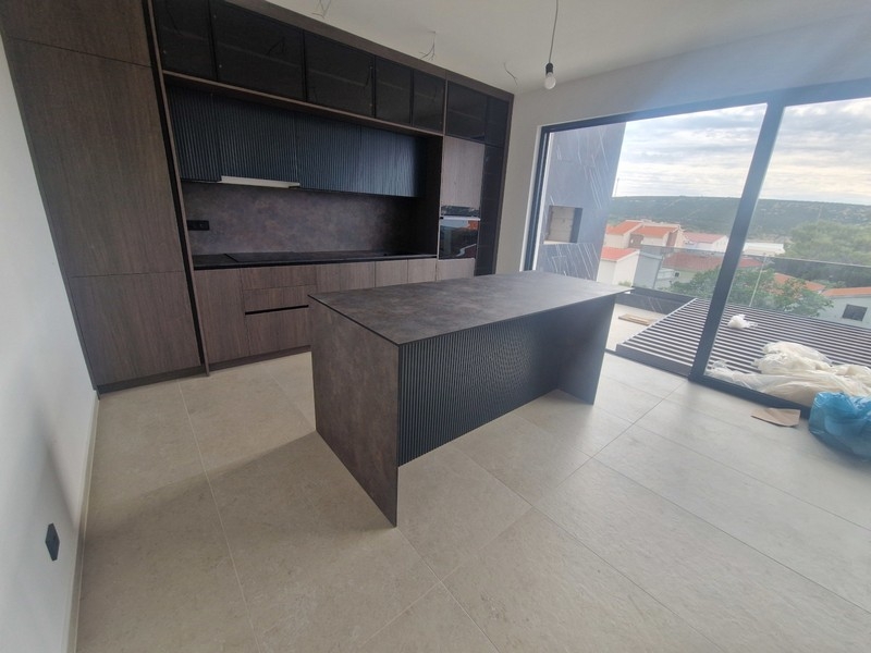 Moderne Einbauküche mit Kochinsel und Meerblick