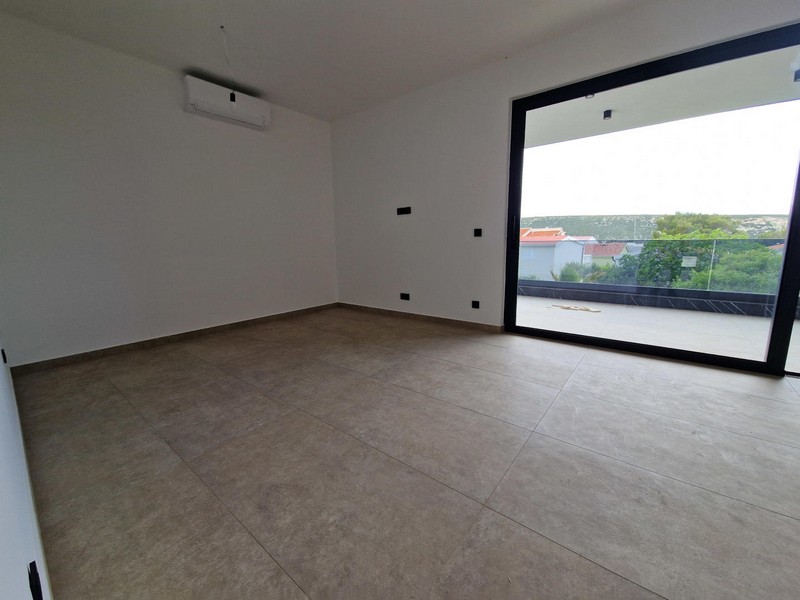 Klimatisiertes Wohnzimmer und Blick auf die Terrasse mit Glasfront.