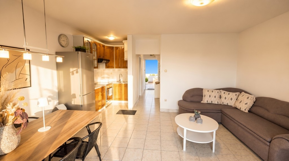 Wohnzimmer mit Küche und Zugang zum Balkon